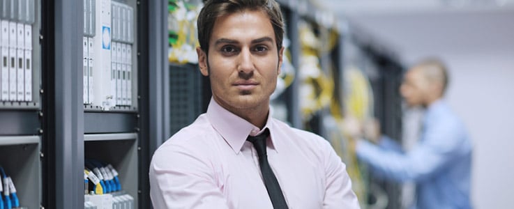 man standing at computer servers