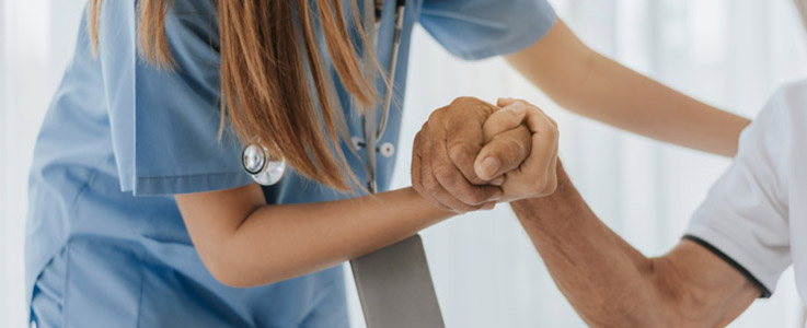 doctor holding hands with elderly patient