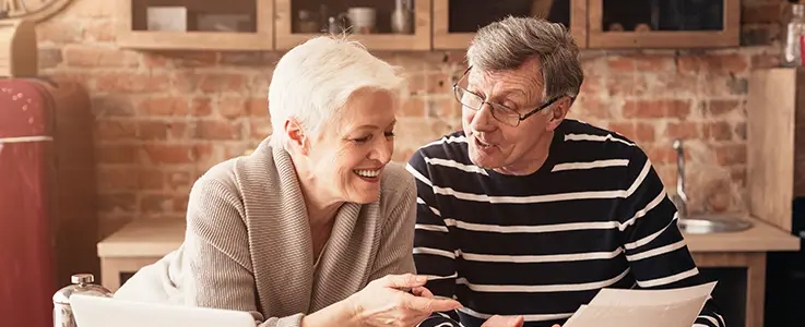 happy retired couple looking over documents