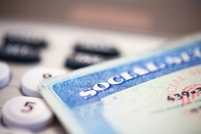An image of a social security card resting with numeric keys on a table